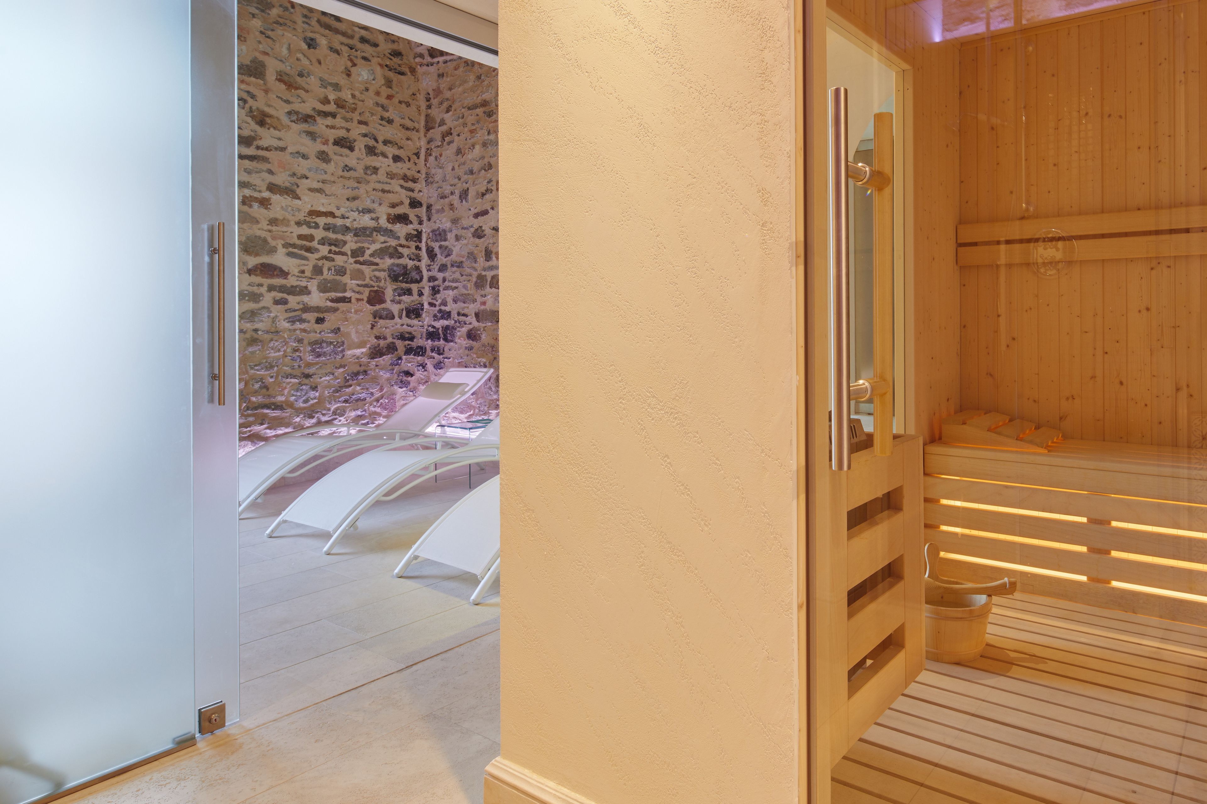 Een sauna met houten banken en een stenen muur.