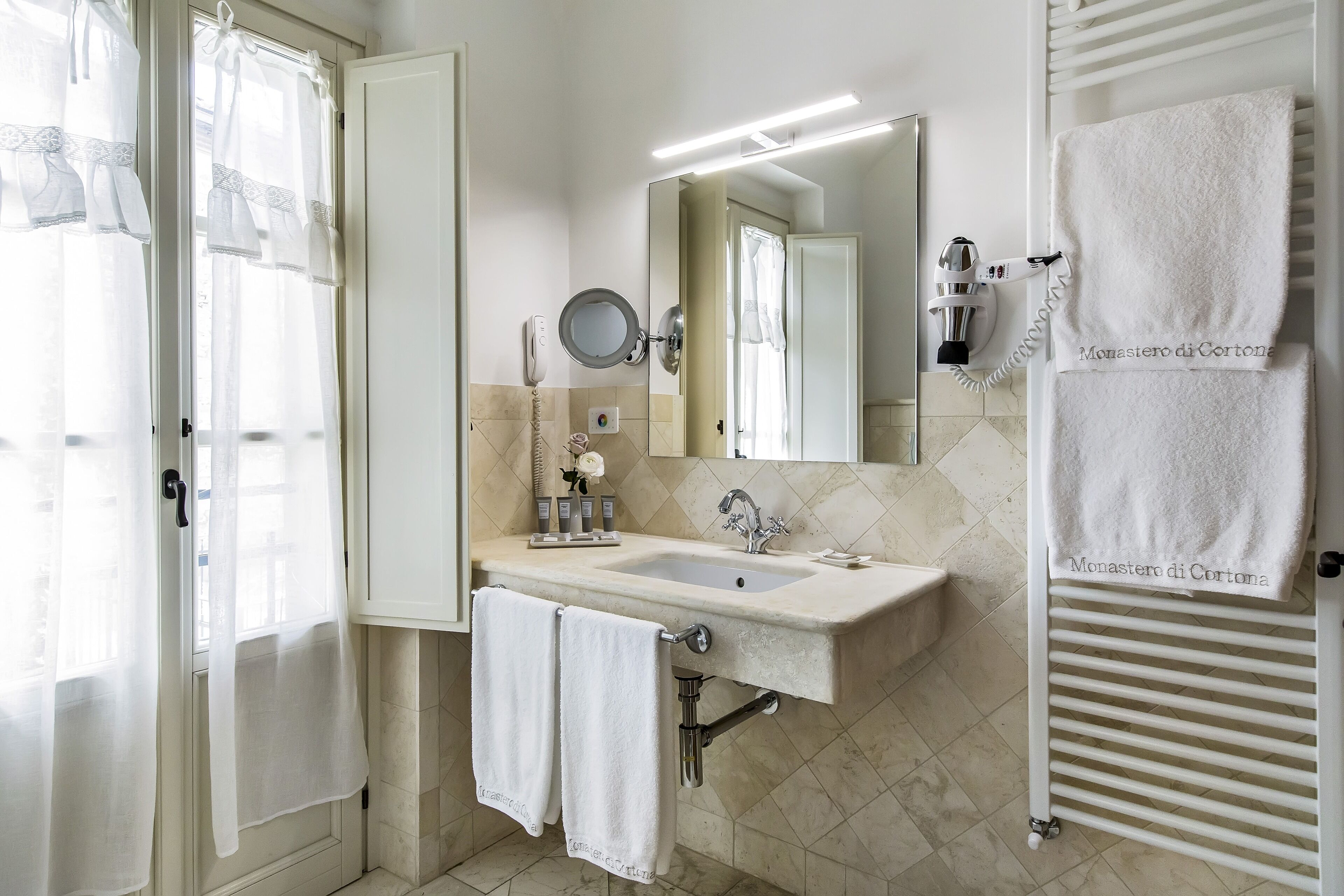 Une salle de bain avec un lavabo, un miroir et un porte-serviettes.