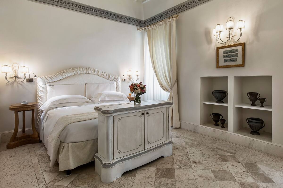 Een slaapkamer met een bed, nachtkastje en een decor kast.