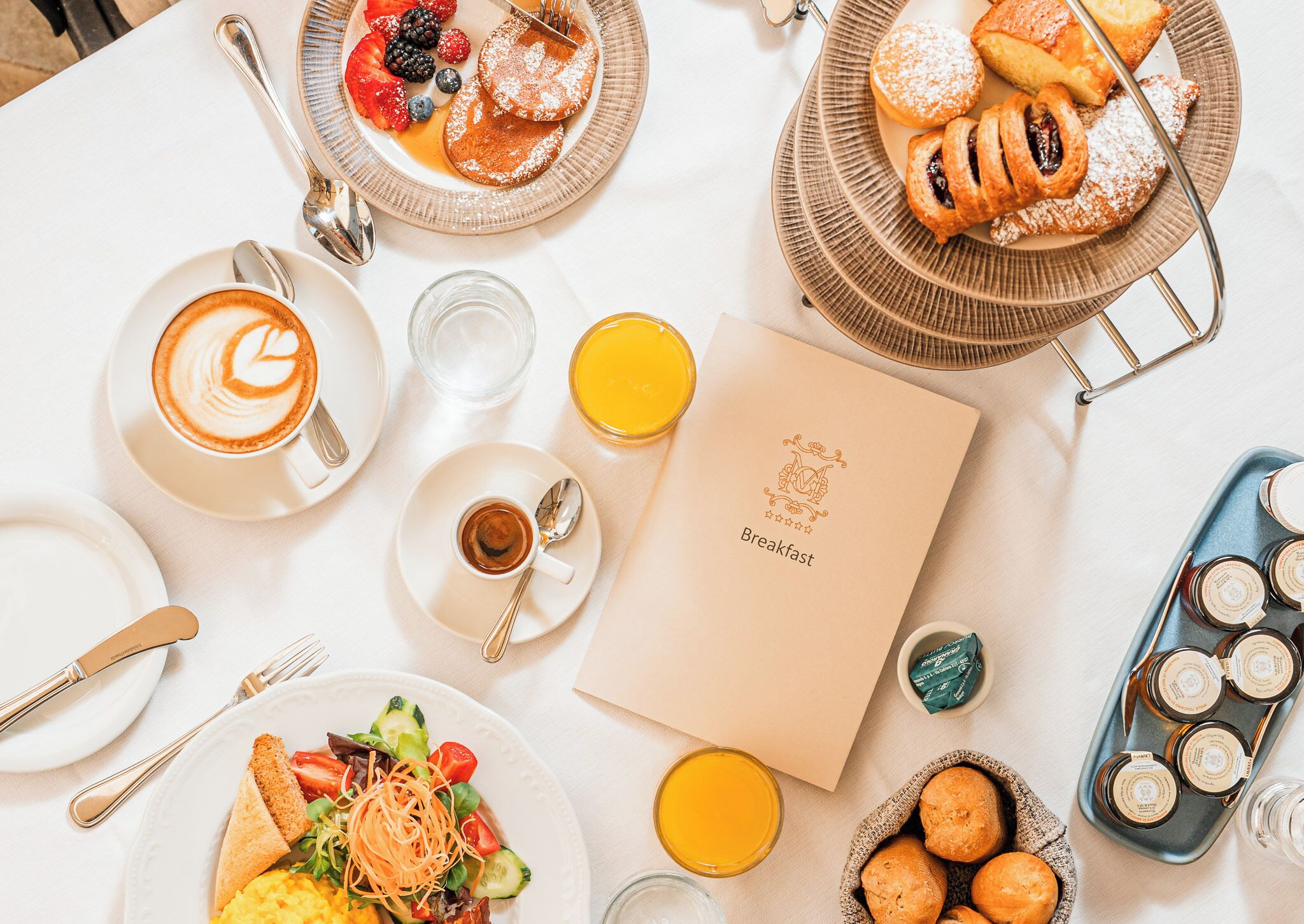 A breakfast setting with various dishes, a coffee cup, and a menu.