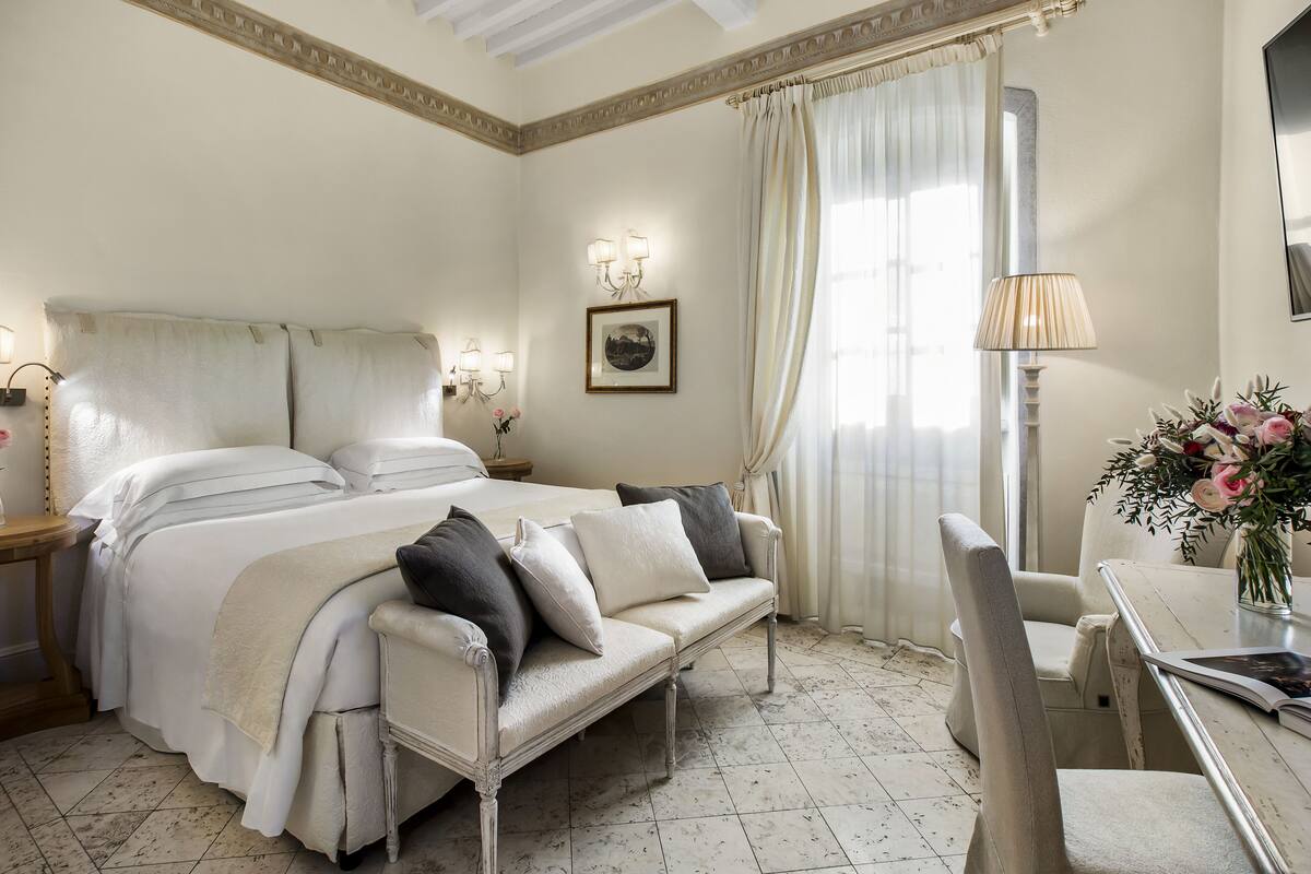 Een hotelkamer met een bed, een bank, een eettafel en een stoel.