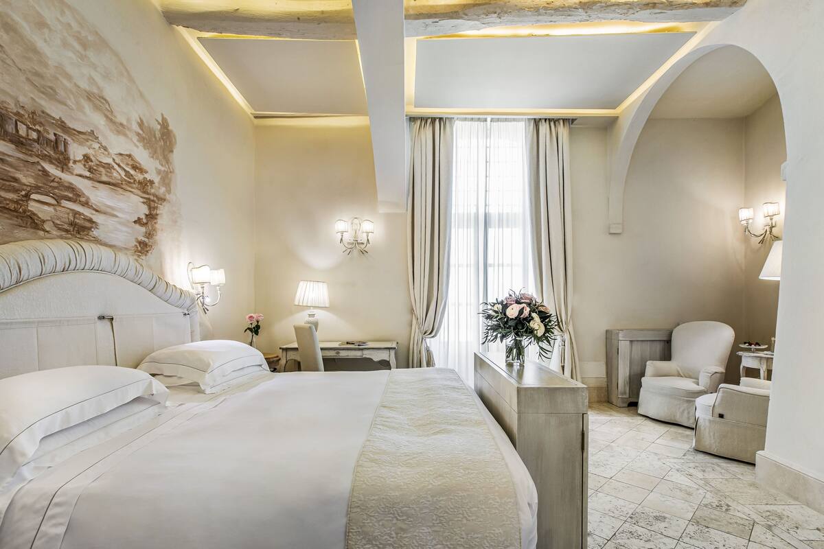 Een hotelkamer met een groot bed, een bureau, een stoel en een kaptafel.