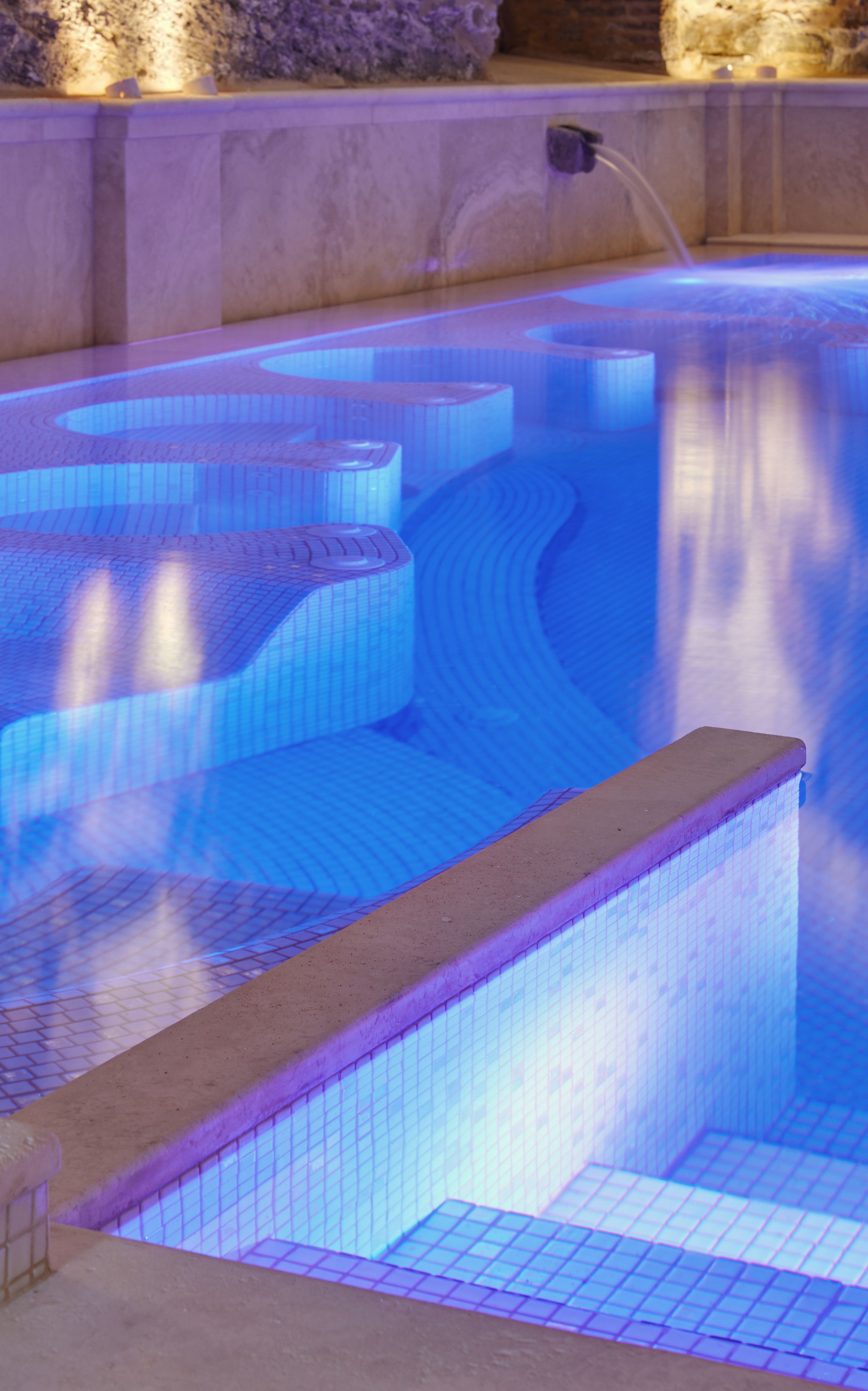 A swimming pool with a unique geometric design and a water feature.