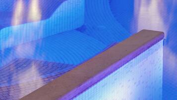 A swimming pool with a unique geometric design and a water feature.