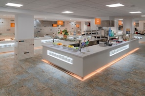A modern, well-lit food display area with various food items and a decorative bird sculpture.