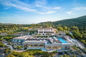 Een modern hotel met een dakterraszwembad, aangelegde tuinen en uitzicht op de omliggende heuvels.