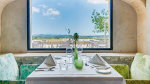 Mesa para dos con vistas a una terraza y montañas.