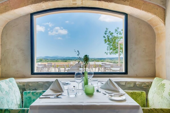 A table set for two with a view of a terrace and mountains. - Carrossa Hotel & Spa (Arta)