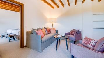Una sala de estar acogedora con un sofá, un sillón y una mesita de noche con una lámpara.