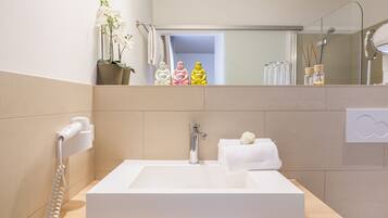 Une salle de bain moderne avec un grand lavabo blanc, un sèche-cheveux et un miroir.
