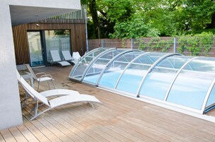 Una piscina al aire libre, sillones reclinables de piscina