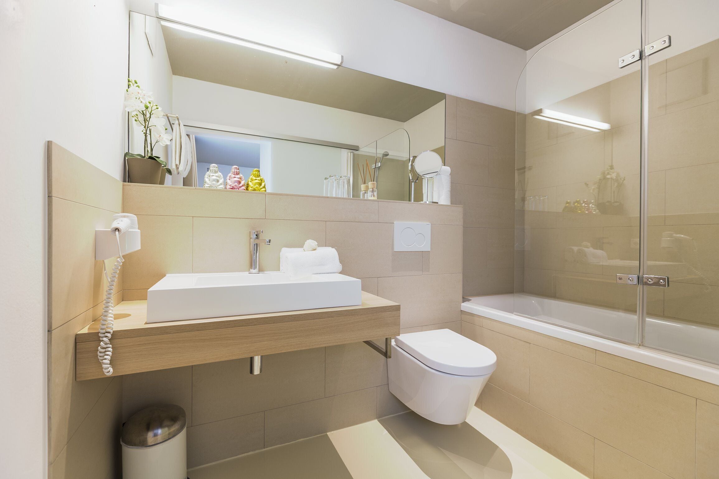 A modern bathroom with a sink, toilet, and shower.