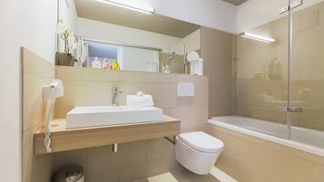 A modern bathroom with a sink, toilet, and shower.