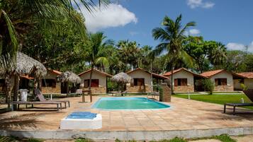 Una piscina al aire libre, camas de piscina gratis, sombrillas