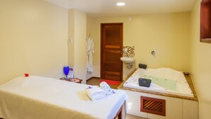 A hotel room with a bed, a small table with a glass, a sink, and a shower area. - Hotel Villa Beija Flor (Jijoca de Jericoacoara)
