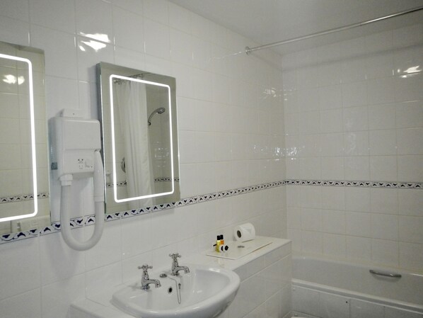 A bathroom with a sink, two mirrors, a shower, and a toilet. - The Burton Hotel and Cloud Nine (Kington)