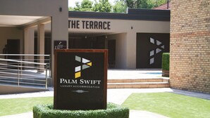 A sign for Palm Swift Luxury Accommodation with a modern design, located in front of a building labeled "The Terrace". - Palm Swift Luxury Accommodation (Brits)