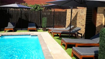 Utomhuspool, parasoller och solstolar