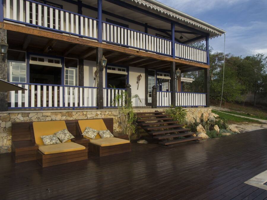 A two-story building with a balcony, stone steps, and wooden flooring.