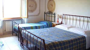 Un dormitorio con dos camas, una ventana y un radiador.