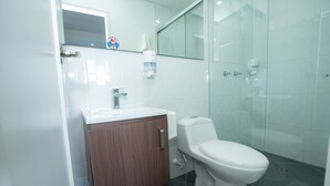 A modern bathroom with a toilet, sink, and shower. - Hotel  Oasis (Rionegro)