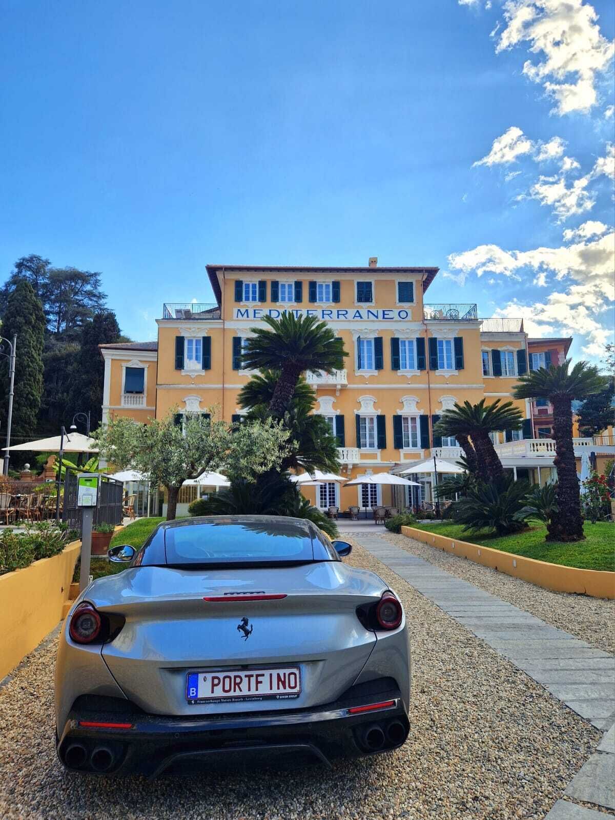 A building with a sign reading 'MEDITERRANEO' and a parked car with a license plate 'PORTFINO'.