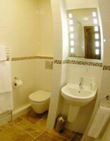 Un baño con inodoro, lavamanos y espejo.