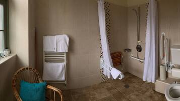 A bathroom with a shower, toilet, and a window with a view.