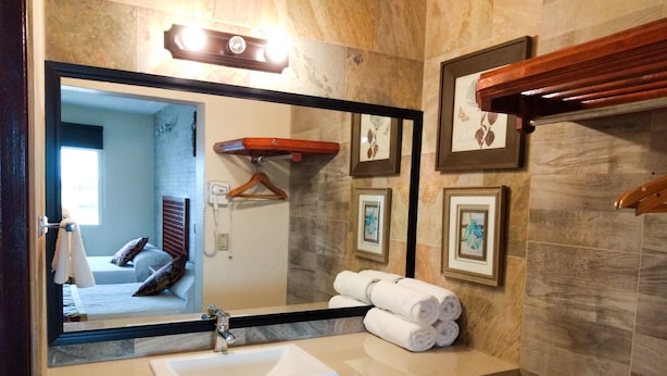 A bathroom with a large mirror, a sink, and towels. - Hotel Posada Santa Fe Sabinas (Sabinas)