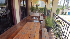 A wooden outdoor seating area with benches and potted plants. - Hotel Posada Santa Fe Sabinas (Sabinas)