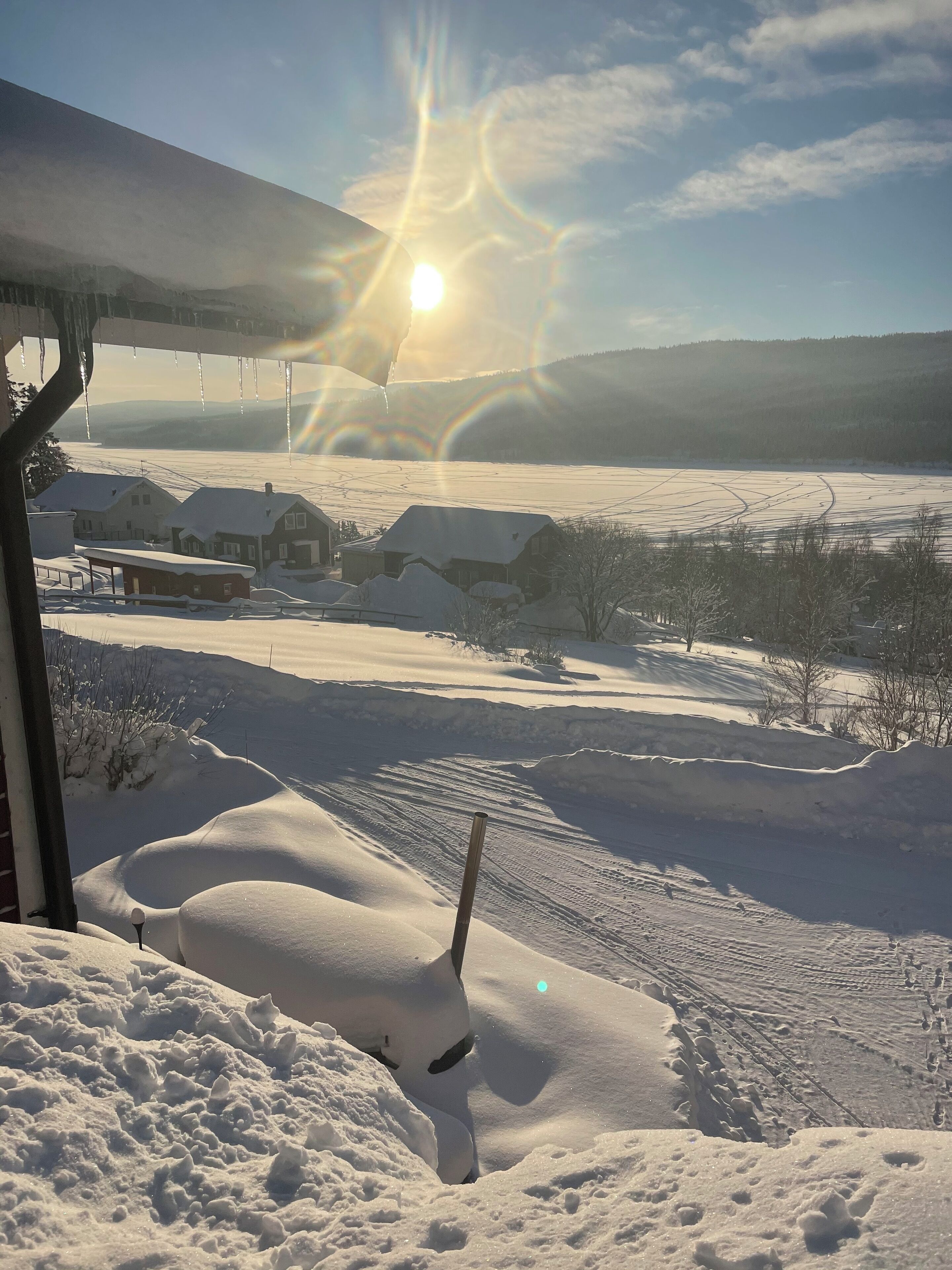 A snowy landscape with houses and a clear sky.