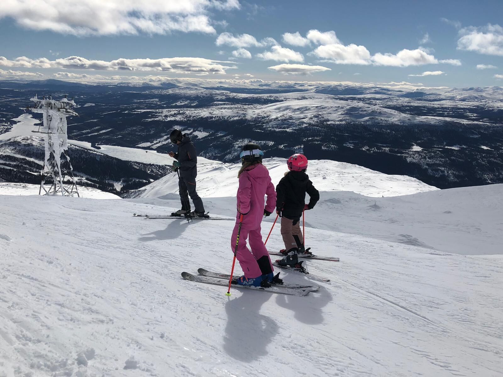A snowy mountain slope with skiers and a ski lift.