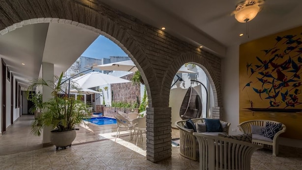 A spacious indoor area with a pool, seating arrangements, and a view of the outside. - Casa Arte Hotel Boutique by HMC - Adults Only (Cartagena)