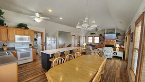 Una cocina amplia con armarios de madera, una isla grande y una zona de comedor con sillas.