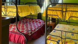 Ein Schlafsaalzimmer mit Etagenbetten, einem Deckenventilator und einem Fenster mit Vorhängen.