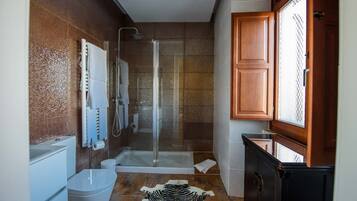 A modern bathroom with a glass-enclosed shower, a bathtub, and a toilet.