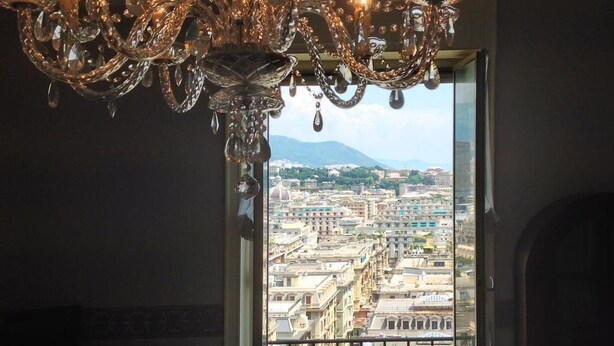 Un candelabro con numerosas velas y una vista de la ciudad a través de una ventana.