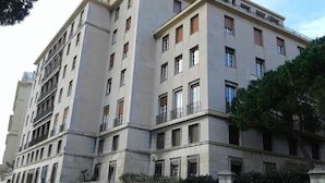 Un edificio de varios pisos con fachada simétrica, ventanas amplias y balcones.