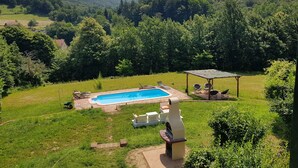 A backyard with a swimming pool, outdoor seating, and a barbecue area. - Family Friendly Farmhouse -  Secluded 2 acres with Private Pool & Stream (Sassello)