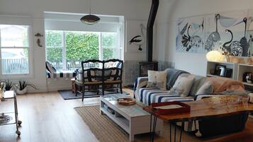 A spacious living room with a large window, a sofa, a coffee table, and a fireplace.