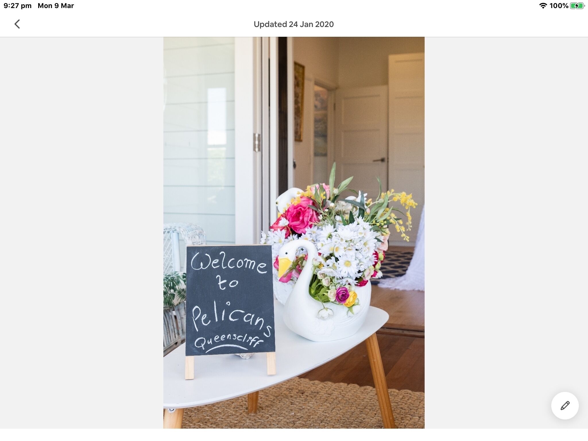 A welcome sign and a floral arrangement at the entrance of a property.