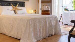 Quarto com uma cama grande, uma decoração em formato de estrela-do-mar e duas pinturas na parede.
