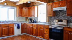 Una cucina con pensili in legno, forno in acciaio inossidabile e piano di lavoro in granito.