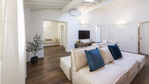 Una sala de estar moderna con un sofá, un televisor de pantalla plana y una planta en maceta.