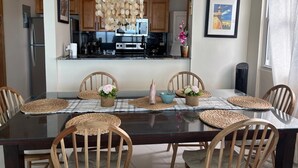 A dining area with a glass table, woven placemats, and wooden chairs. - Luquillo, 13th Floor with Ocean Front! (Luquillo)
