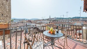 Ein Balkon mit Tisch, Stühlen und einer Obstschale.