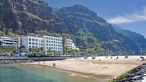 A coastal hotel with a rocky shoreline, a clear view of the sea, and a mountainous backdrop. - Home for Nature Tourism, Madeira Island LAURISHOUSE, Nature and Sea (Prazeres)