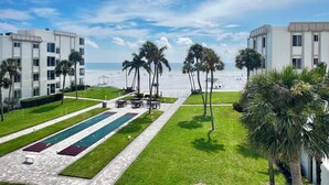 A resort with a pool area, palm trees, and a view of the beach. - Island House Beach Resort 13N (Siesta Key)