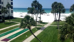 A hotel courtyard with a pool table, a tennis court, and a beach view. - Island House Beach Resort 13N (Siesta Key)