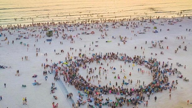 A beach with a large crowd forming a heart shape on the sand. - Island House Beach Resort 13N (Siesta Key)